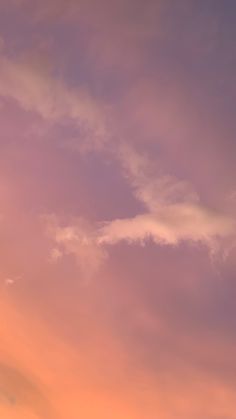 an airplane is flying high in the sky at sunset with clouds behind it and one plane on the ground