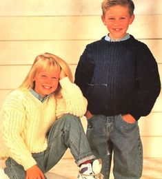 two children in sweaters and jeans posing for a photo