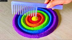 a person is using a comb to make a rainbow cake