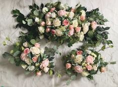 flowers arranged in the shape of an x on a white sheet