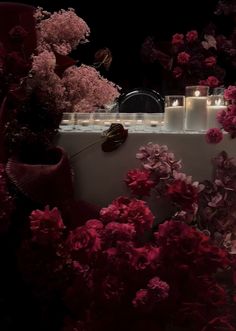 pink flowers and candles on a table in the dark