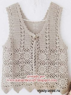 a crocheted vest is hanging on the wall