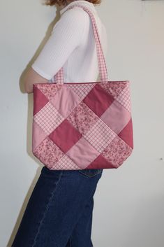 a woman carrying a pink and white quilted tote bag on her left side