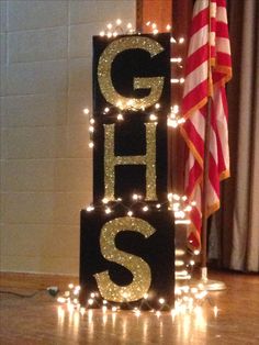 lighted letters spelling out the word g is for g's on top of a wooden floor