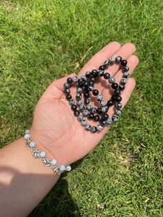 "Snowflake Obsidian Crystal Bracelet 9mm Round Snowflake Obsidian bead Approximate Size: Flexible elastic. This means that It will stretch to the appropriate size of your wrist. I am someone with a larger wrist, and these still fit comfortably. Snowflake Obsidian is a stone of purity, providing balance for body, mind, and spirit. It helps to recognize and release \"wrong thinking\" and stressful patterns. It promotes dispassion and inner centering. With the aid of this stone, isolation and lonel Snowflake Obsidian Crystal, Obsidian Crystal, Obsidian Bracelet, Metaphysical Healing, Bracelet Crystal, Snowflake Obsidian, Diy Bracelet, Crystal Bracelet, Gemstone Bracelets