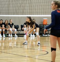 the volleyball players are waiting for the ball to come towards their opponents on the court