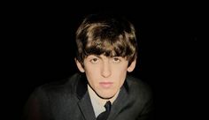 a young man in a suit and tie looking at the camera with an intense look on his face