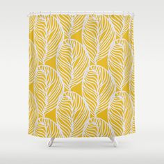 a yellow shower curtain with white leaves on it