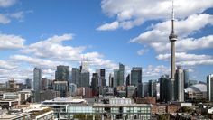 the city skyline is full of tall buildings and skyscrapers with clouds in the sky