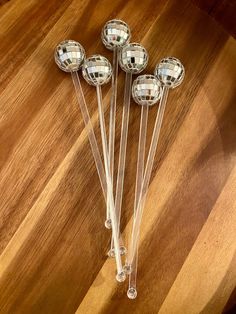 four clear glass balls sitting on top of a wooden table