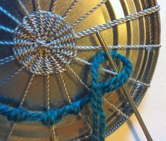 the yarn is being used to make an ornament for something that looks like a spinning wheel