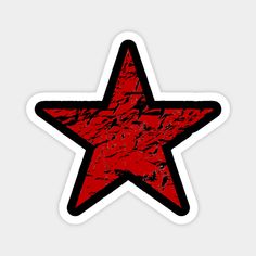 a red and black star sticker on a white background, with some dark spots