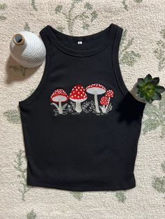 This adorable black crop top is the perfect basic top for any casual outfit but can also be used to elevate any look. It is a solid item to keep in your closet. It is flattering and comfortable. The sleeveless racerback crop is made of cotton, polyester and spandex. It is very soft, stretchy, breathable, and snug to your skin. Mushroom design is machine embroidered and made to order. Crop top fits true to size so whatever is your regular size will fit.  It is available in brown and white and the same sizing applies for those colors as well. Don't hesitate to reach out to me if there are any problems with your order. Mushroom Crop Top, Embroidery Crop Top, Crop Top Design, Crop Top Fits, Crop Top Designs, Embroidered Crop Tops, Mushroom Design, Workout Crop Top, Black Crop Top