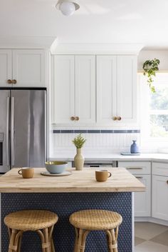 two stools sit at the center of a kitchen island