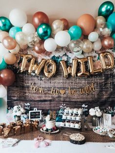 a table with balloons, cake and decorations