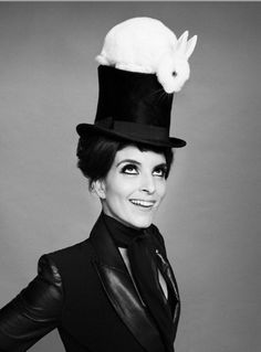 a woman wearing a top hat with a rabbit on it's head and black leather jacket