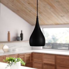 a kitchen with wooden cabinets and black pendant lights hanging from the ceiling over the island