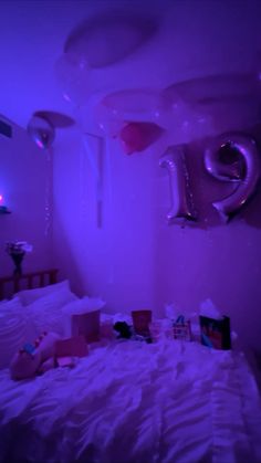 a bed in a room with balloons floating from the ceiling