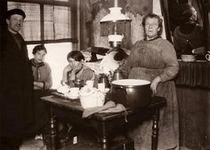 an old black and white photo of people in a kitchen