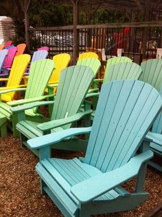 there are many different colored chairs in the yard