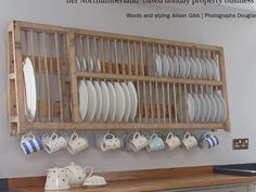 a wooden shelf filled with dishes and cups