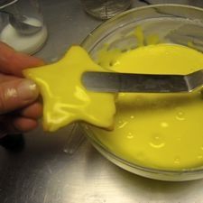 a person is holding a knife over some yellow liquid