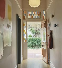 an entryway with stained glass windows and doors leading to the front door is shown