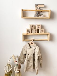 two wooden shelves with clothes and toys on them, against a white wall in the corner