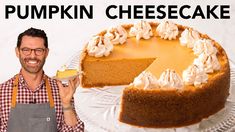 a man holding a glass in front of a pumpkin cheesecake on a cake plate