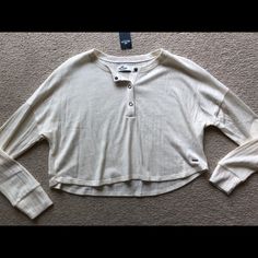 Hollister Women’s Long Sleeve Cropped Henley Top Shirt Ribbed Cream Size Xs New With Tags White Button-up Top For Loungewear, Casual Long Sleeve Cream Blouse, Cream Long Sleeve Casual Blouse, Casual Cream Long Sleeve Blouse, Trendy Long Sleeve Cream Top, Trendy Cream Long Sleeve Tops, Cream Long Sleeve Shirt For Day Out, Casual Cream Tops For Fall, Trendy Cream Button-up Tops