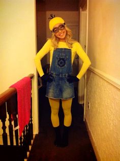 a woman dressed as a minion standing in a hallway