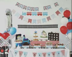 a train themed birthday party with balloons and streamers on the wall, cake table