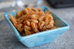 a blue bowl filled with shrimp on top of a table