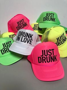 neon colored hats with just drunk written on them