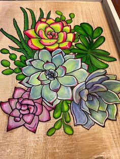 a painting of succulents and other flowers on a wooden surface