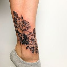 a woman's leg with a rose tattoo on it