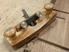 a wooden toy with metal knobs on it