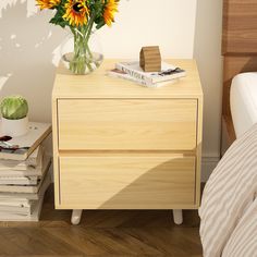 a nightstand with flowers and books on it