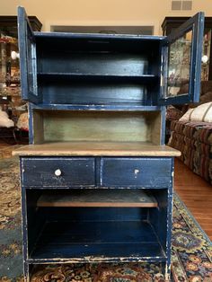 an old blue dresser with two open shelves