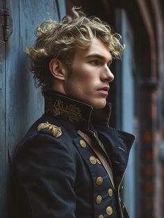 a man with curly hair is leaning against a wall and looking off to the side