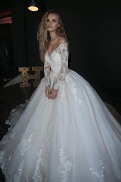 a woman in a white wedding dress posing for the camera with her hands on her hips