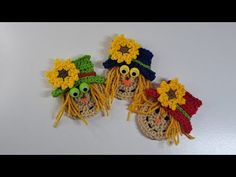 two crocheted scarecrows with hats and sunflowers on their heads