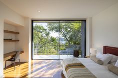 a bedroom with a bed, desk and sliding glass doors