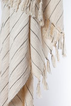 a white and black striped blanket with tassels