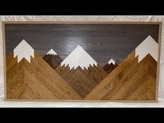 an art piece made out of wood with mountains and trees on the sides, in front of