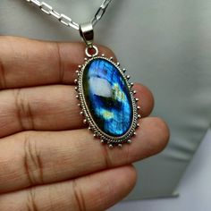 Stone Name            :  Labradorite  Pendant Weight      : 11 Grams Approx. Stone Size                : 29 x 16 x 6 mm Approx. Silver Purity             : 925 Sterling Silver Stone Shape           : Oval Shape Stone Color             :  Blue Flashy   Stone Cut                : Smooth Cabochon * Cut & Polished in India * 100% natural & genuine * All the pieces are stamped with 925 as a hallmark for 925 Sterling Silver. * Measurements & weight are close approximations * We take order work as well Oval Cabochon Labradorite Jewelry, Oval Labradorite Cabochon Jewelry, Blue Labradorite Gemstone Necklace, Blue Cabochon Moonstone Jewelry, Blue Gemstone Necklace In Labradorite, Handmade Blue Labradorite Gemstones, Blue Round Labradorite Jewelry, Unique Blue Moonstone Jewelry, Oval Blue Moonstone Necklace