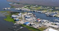 an aerial view of a marina with many boats and buildings in the water, surrounded by land