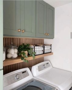 a washer and dryer in a room with green cupboards on the wall