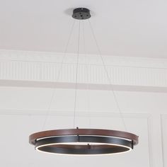 a circular light fixture hanging from the ceiling in a room with white walls and ceilings