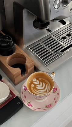 a cup of coffee sitting on top of a saucer next to a wooden coaster